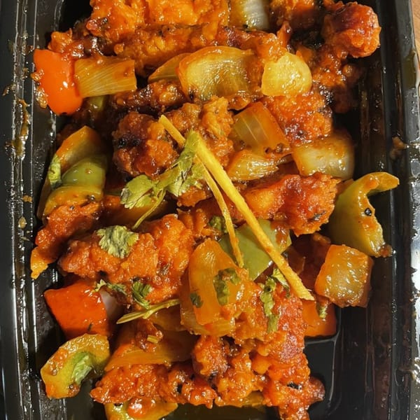 Close-up of Bay Leaf Indian Kitchen's chili chicken with bell peppers, onions, and cilantro.